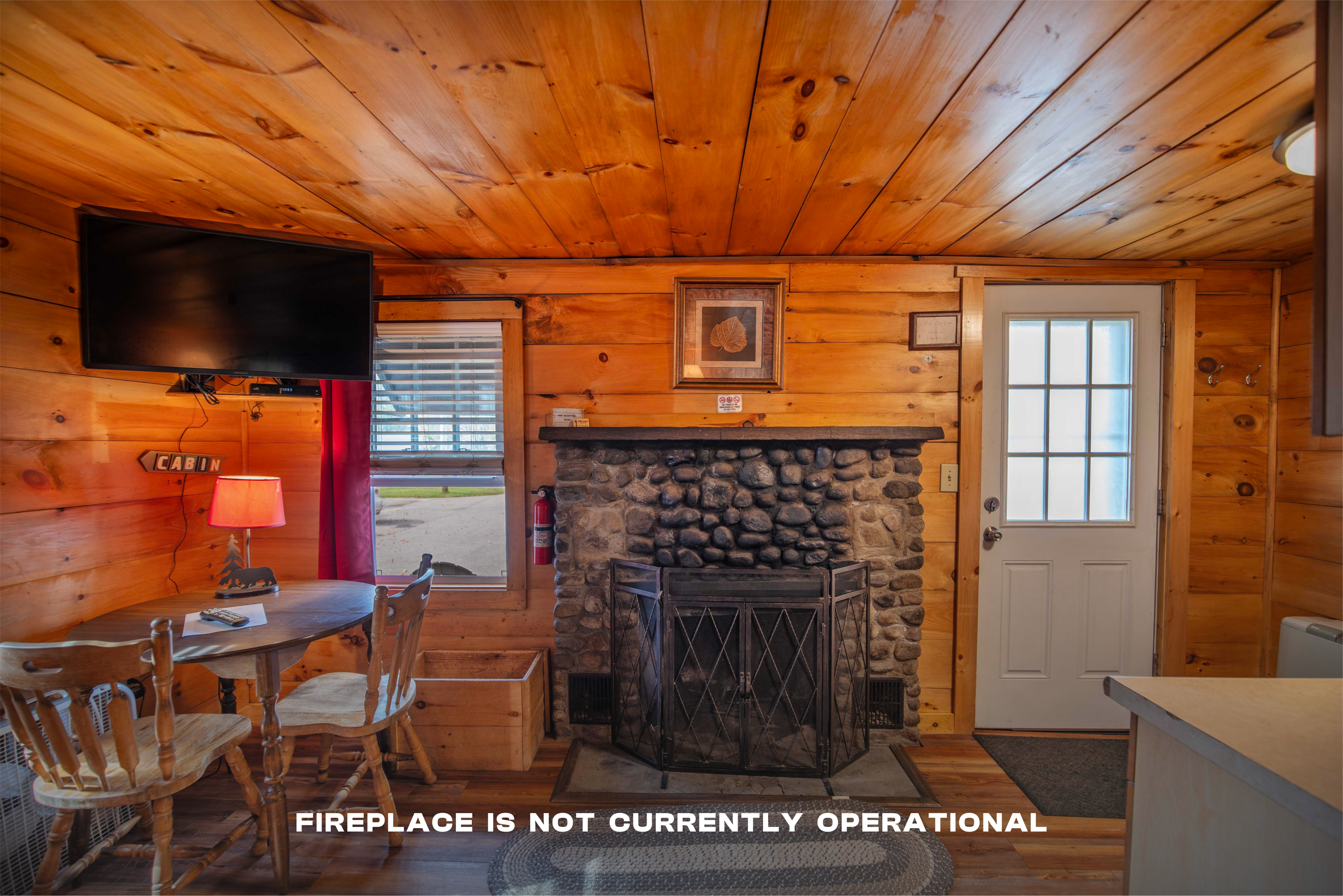 Cozy up by the riverstone fireplace with mantle in Lost River cabin. #MountainViews #TravelNH #WoodBurningFireplace #RusticMeetsModern