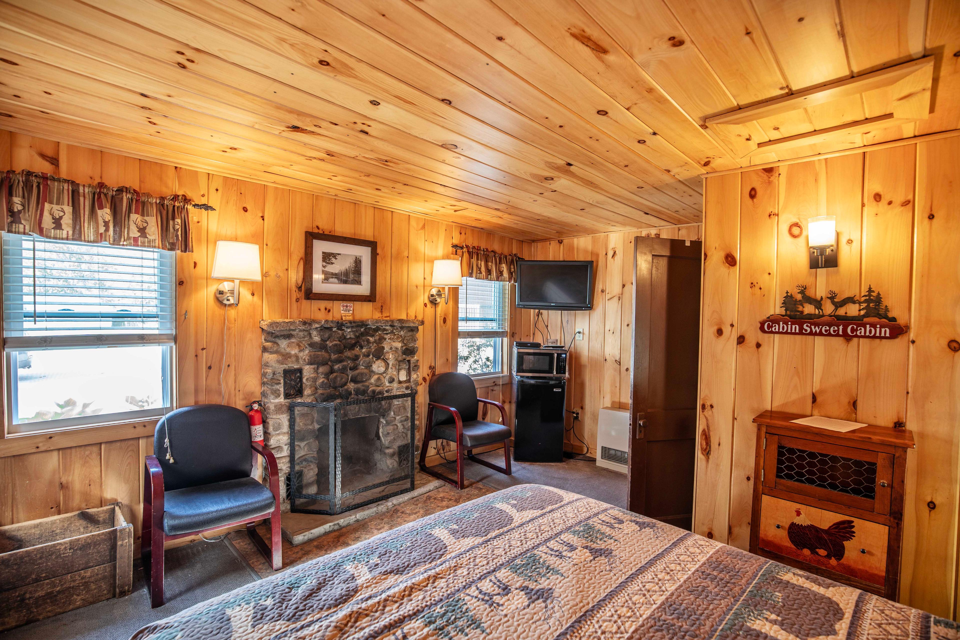 Cozy interior with a riverstone fireplace in Deer Haven cabin. #CozyCabin #FireplaceNights #RusticCharm #NatureLovers