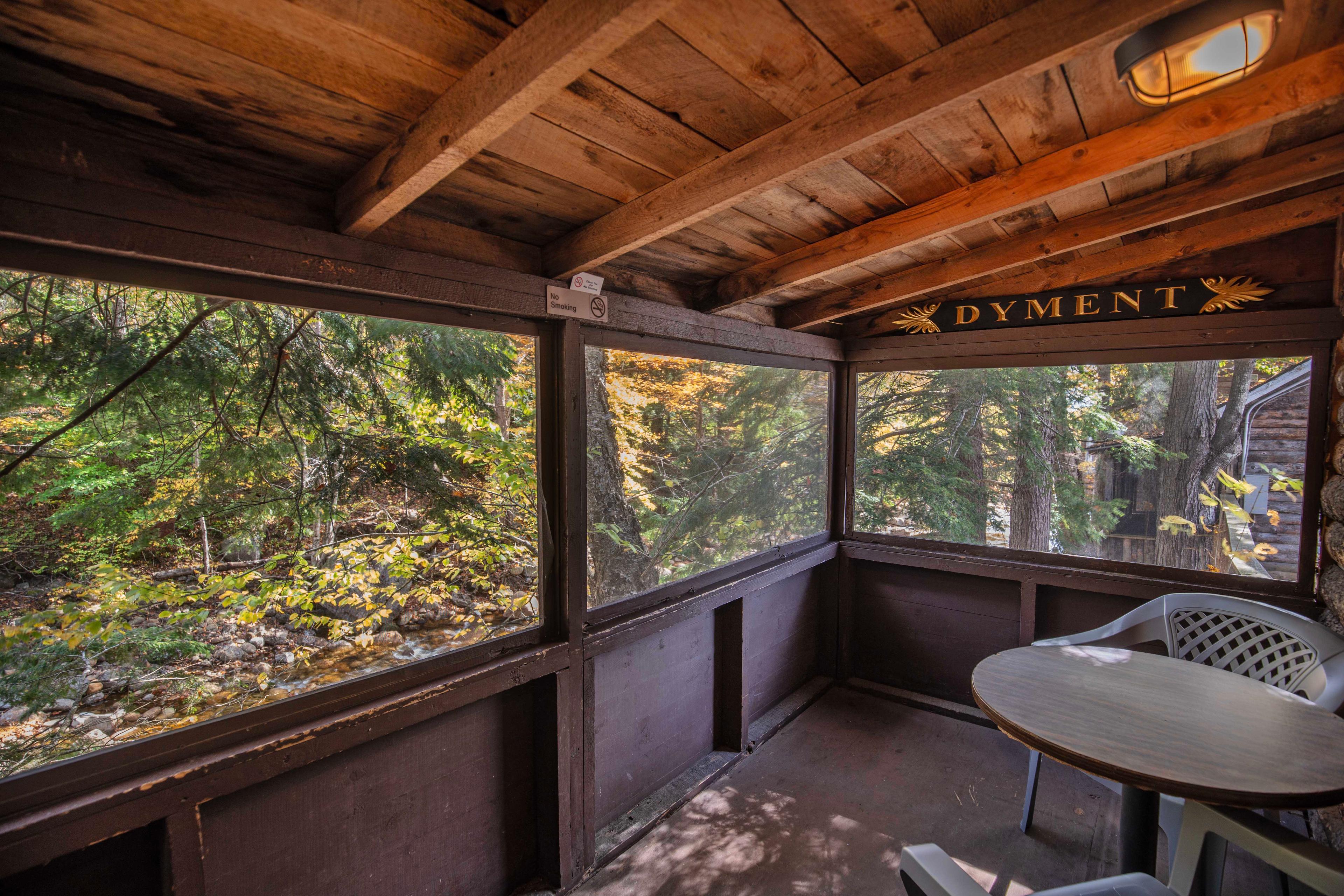 Screened-in porch with stunning views of the Pemigewasset River at The River Otter. #RiverViews #PeacefulRetreat #EscapeToNature #MountainViews