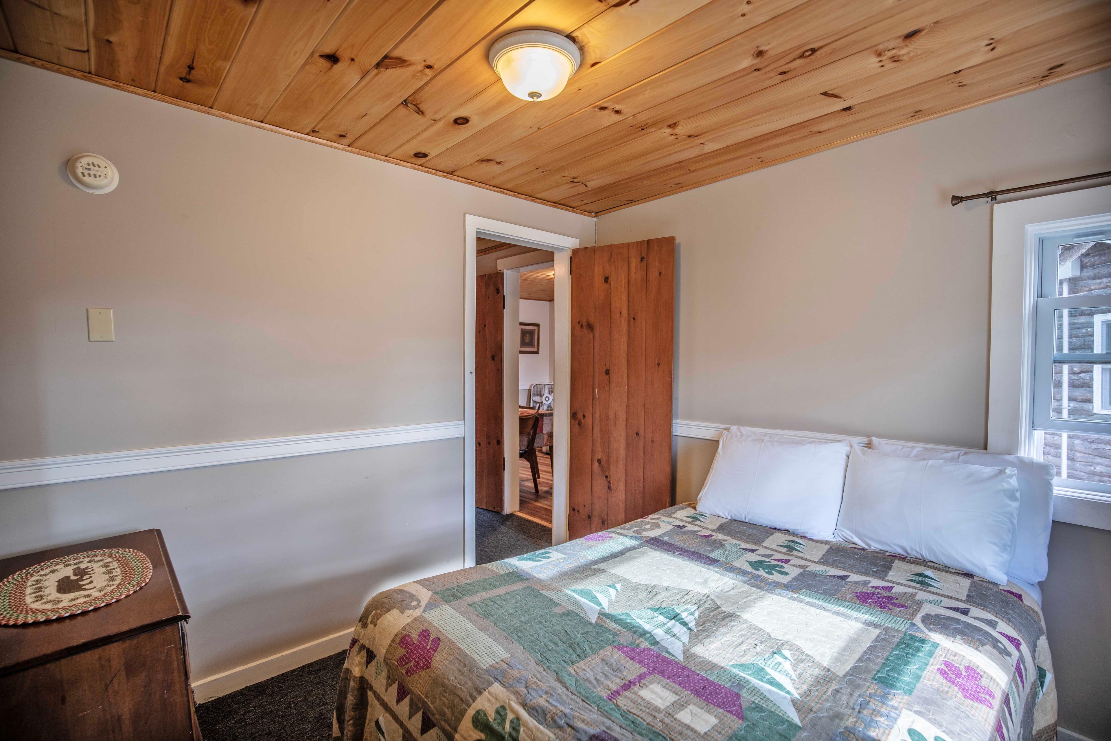 Bedroom with plush queen-sized bed for a restful night's sleep at Mount Lincoln. #MountLincoln #PemiCabins #PemigewassetRiver #RusticCabin #LincolnNH