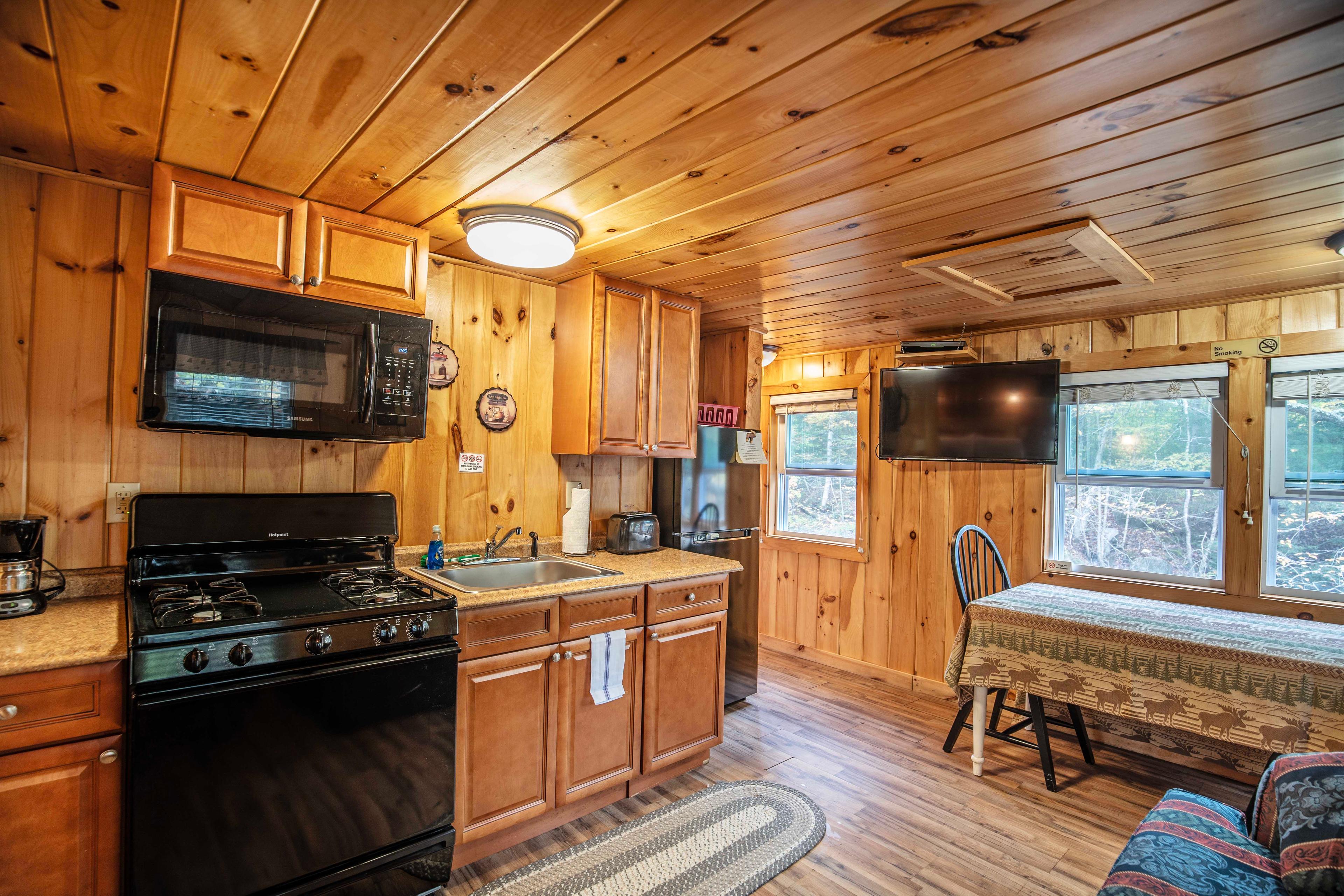 Gas/electric-powered stove creating a cozy atmosphere in Fox Hollow cabin. #GasStoveAmbiance #RusticMeetsModern #EveningRelaxation #FullyEquippedKitchen