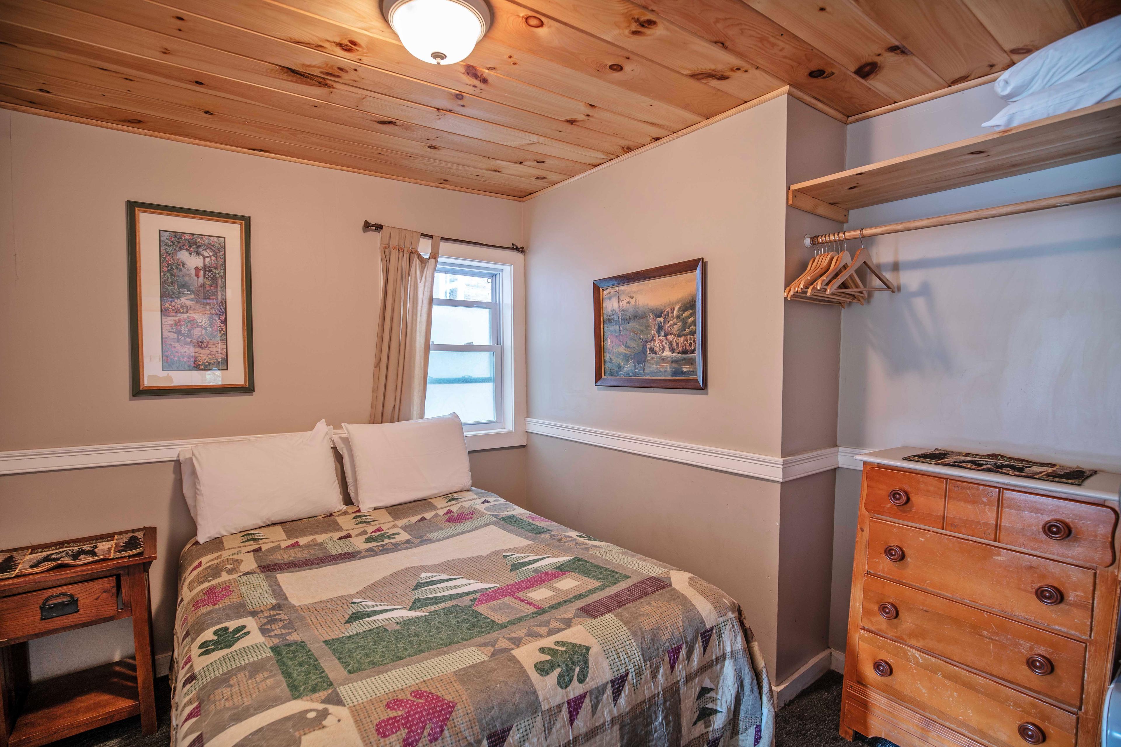 Two separate bedrooms with full-sized beds at Mount Lincoln cabin. #WhiteMountains #FamilyGetaway #GroupRetreat #CozyLivingRoom