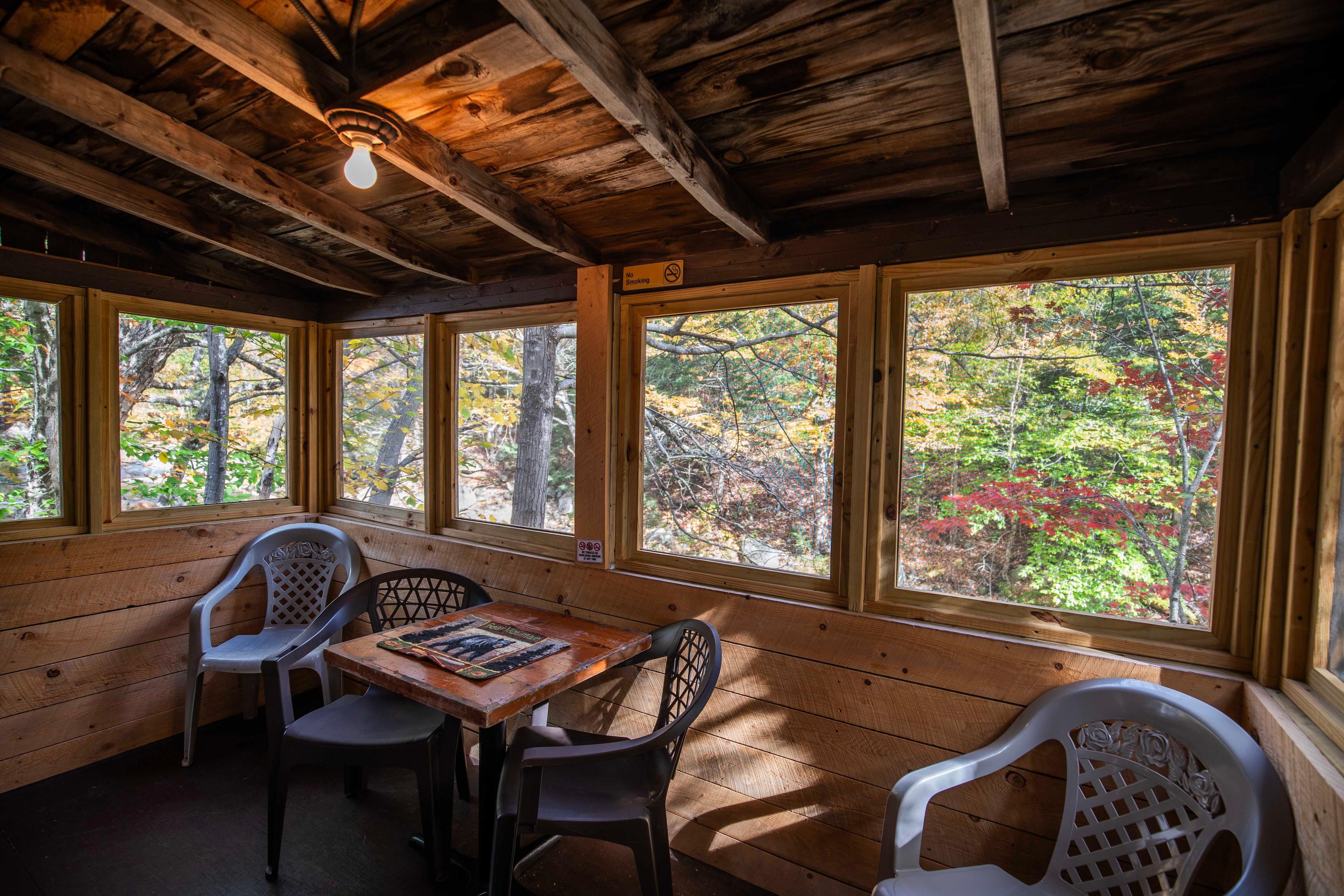 Relax on the screened-in porch of The Bears Den, overlooking the Pemigewasset River. #MountainRetreat #PeacefulEscape #UnforgettableGetaway #CabinInTheWoods