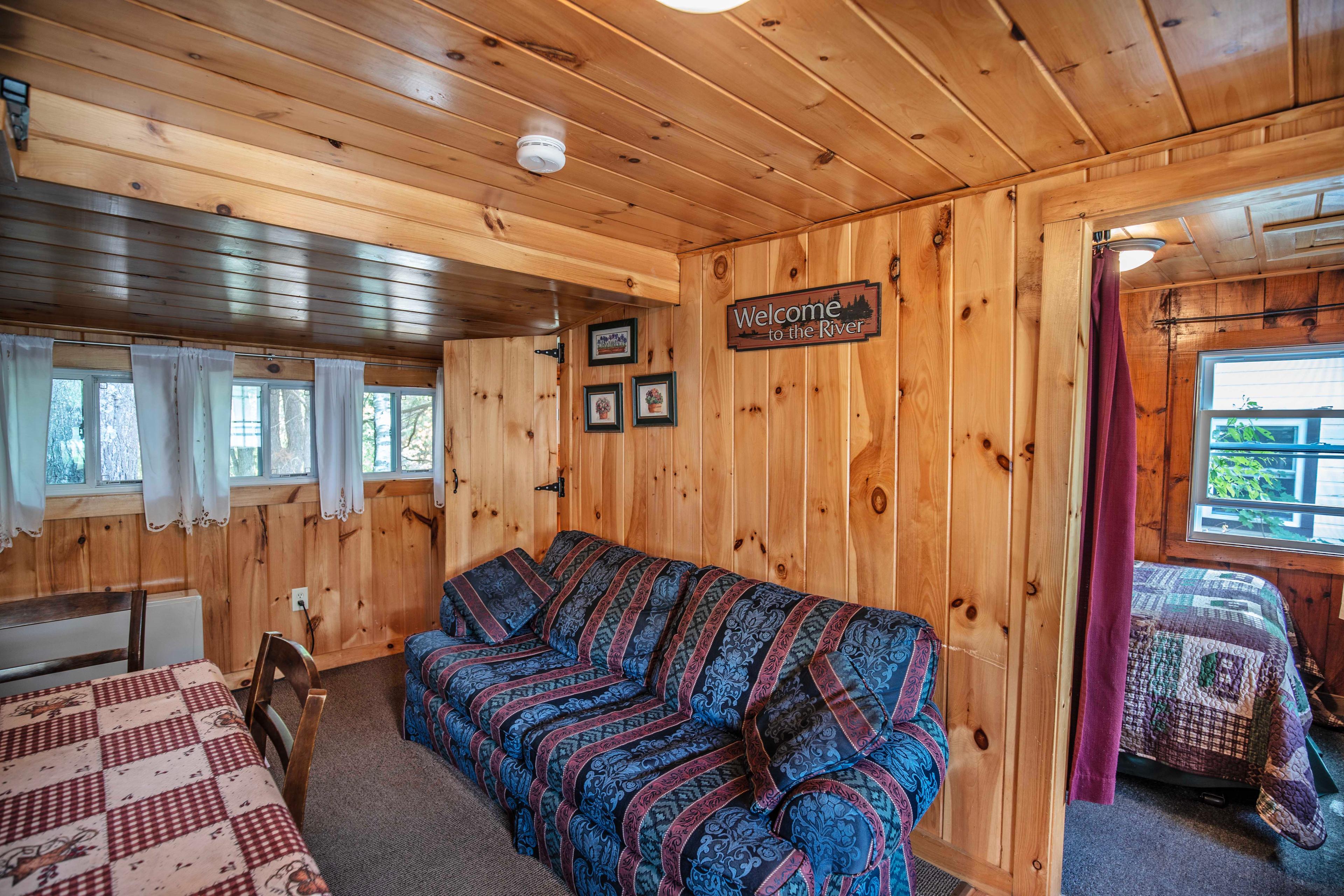 Spacious and comfortable living space at Eagle Cliff cabin. #YearRoundComfort #RiverfrontViews #NatureEscape #ExploreNH