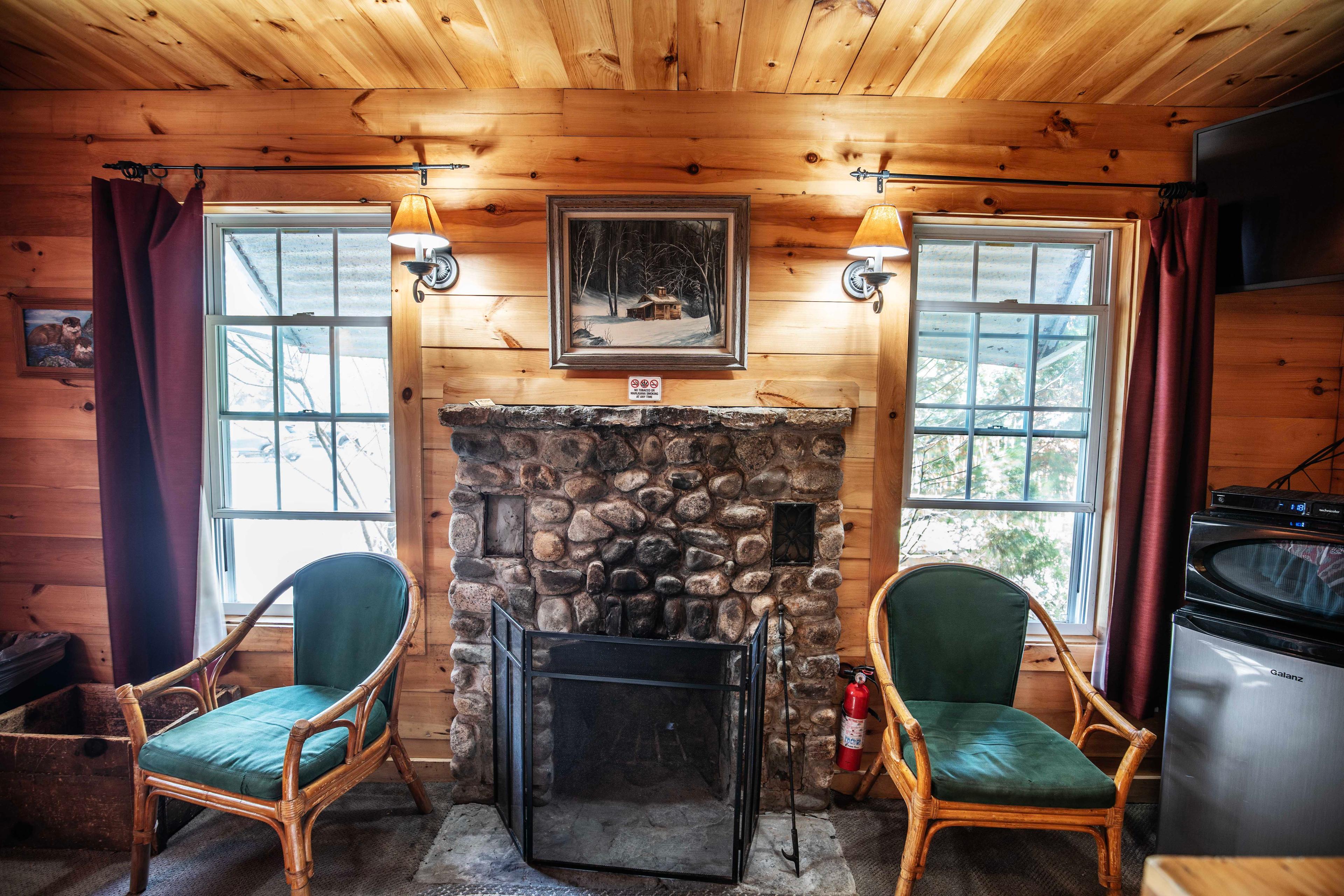 Cozy ambiance created by the wood-burning fireplace in The River Otter. #WoodBurningFireplace #RusticMeetsModern #RiverViews #PeacefulRetreat