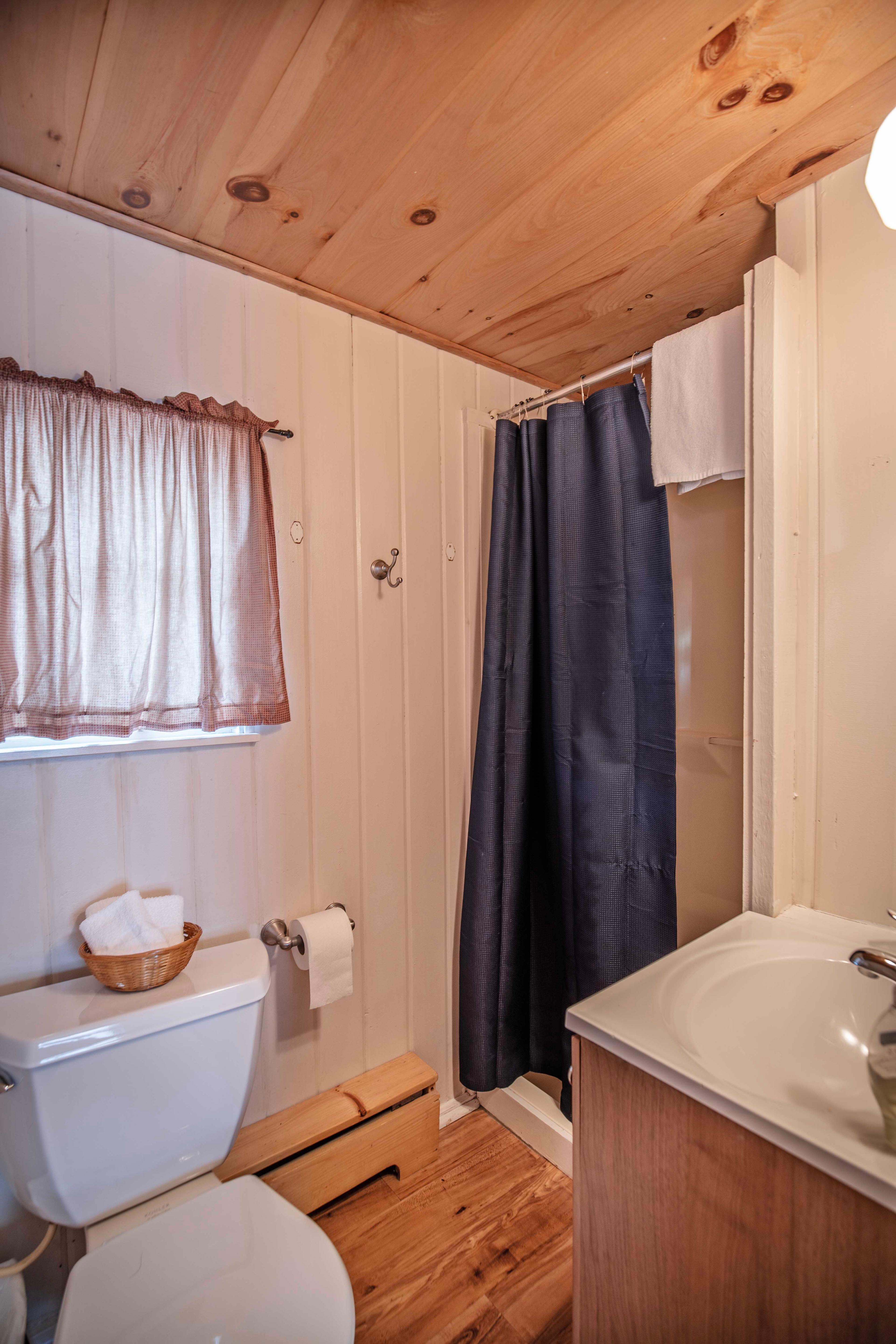 Full bathroom with stand-up shower adjacent to the bedroom in The Basin cabin. #FullBathroom #HiddenGem #NatureBeauty #AdventureAwaits