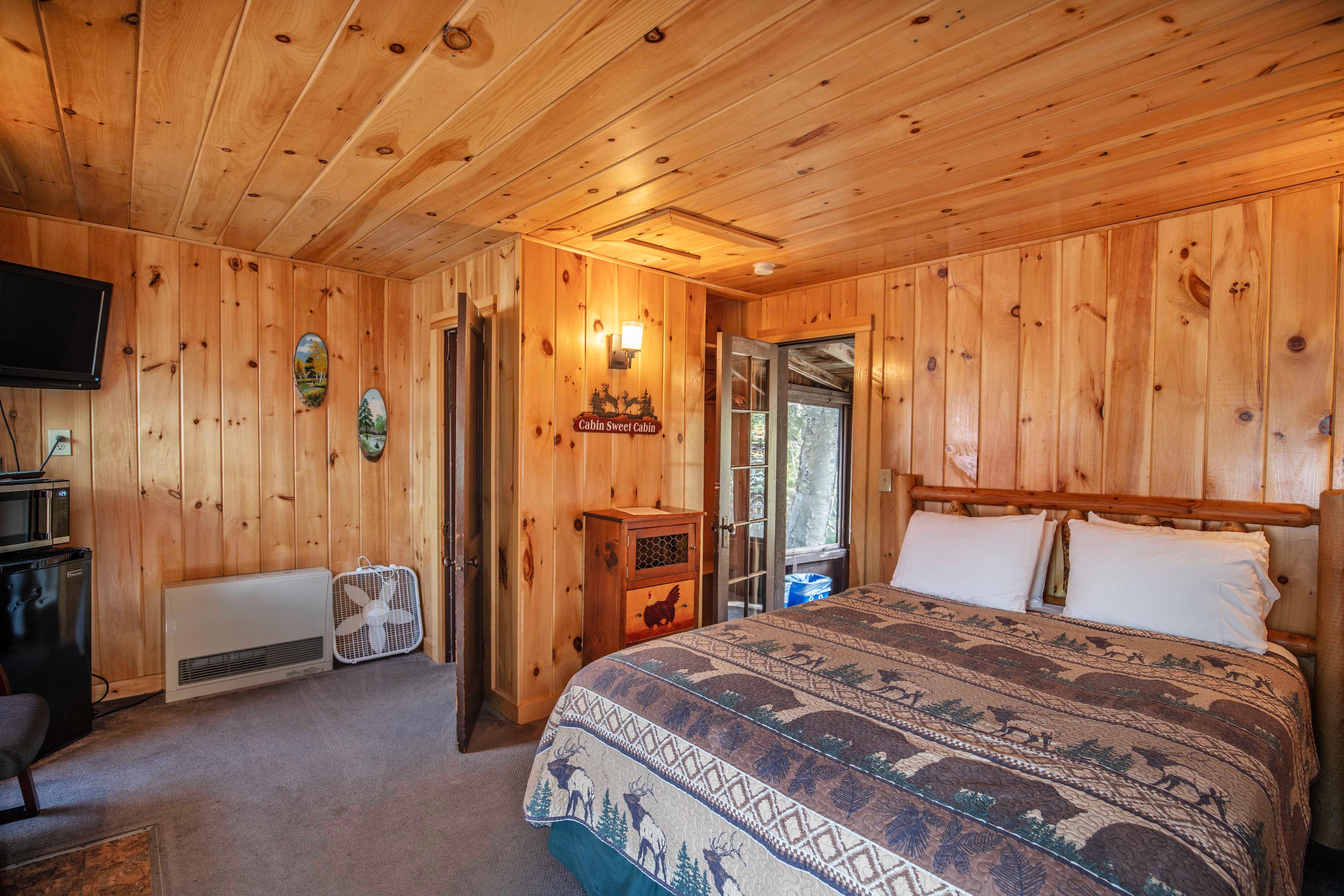 Comfortable bedroom with a plush queen-sized bed in Deer Haven cabin. #CabinGetaway #ScenicViews #YearRoundComfort #VacationRental