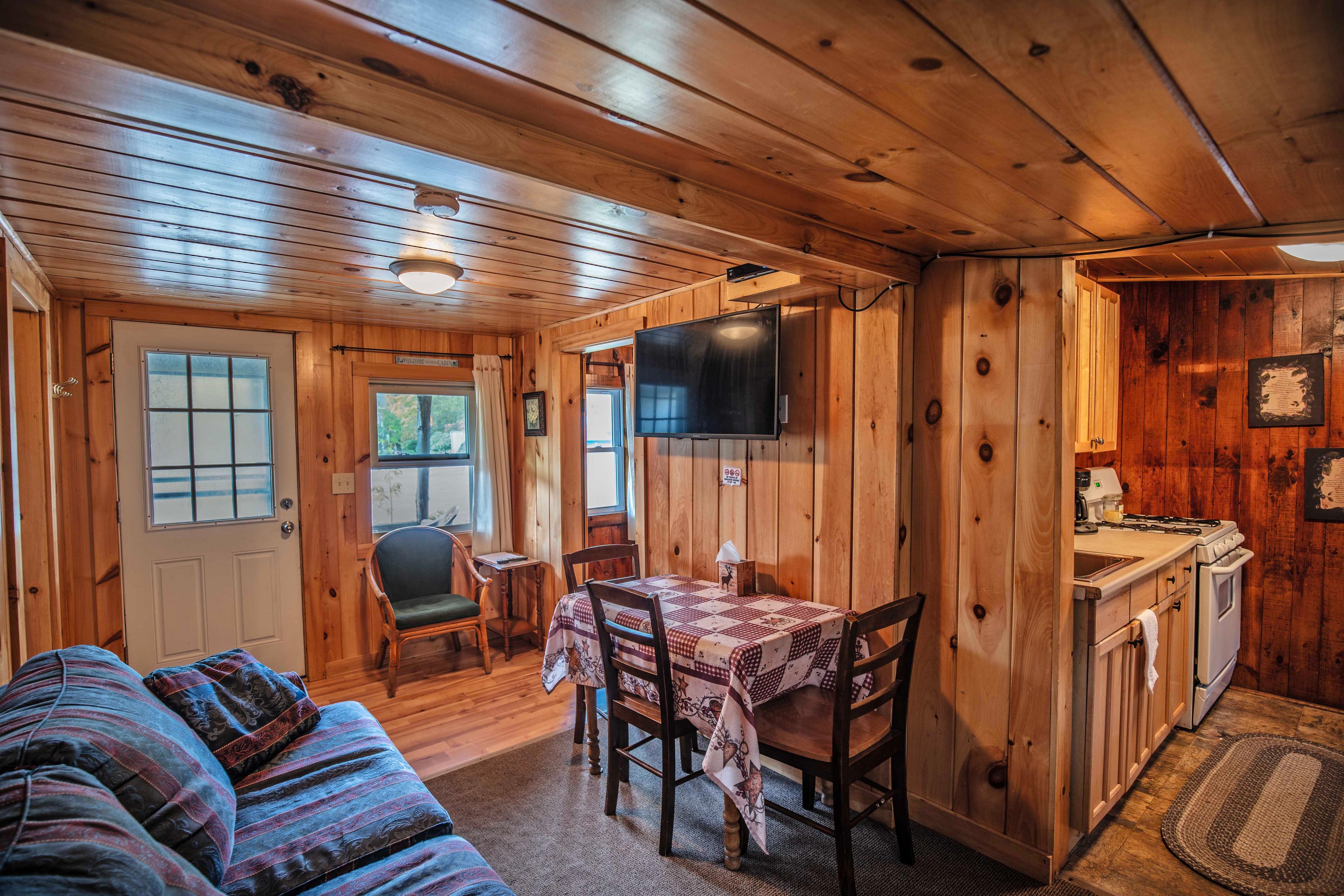 Comfortable couch and dining table setup inside Eagle Cliff cabin. #CabinLife #OutdoorLiving #Cookout #PicnicTable