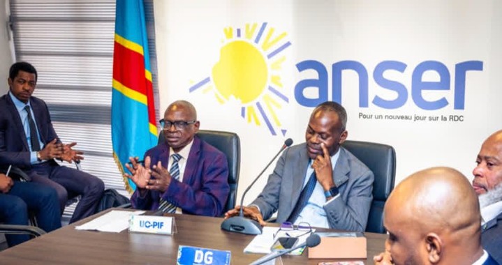 Men in a meeting with the DR Congo flag and "anser" logo in the background.