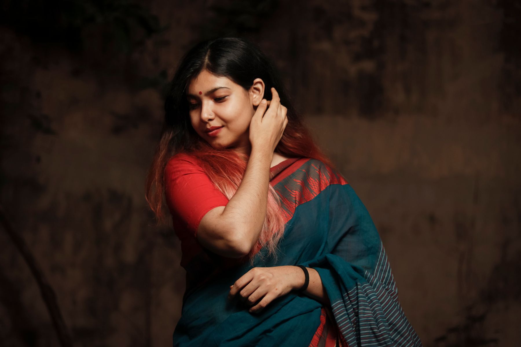 Woman wearing a blue saree with a red blouse