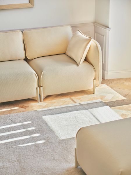 Svetlá modulárna pohovka Linka s vankúšom v minimalistickej obývačke so slnečným svetlom