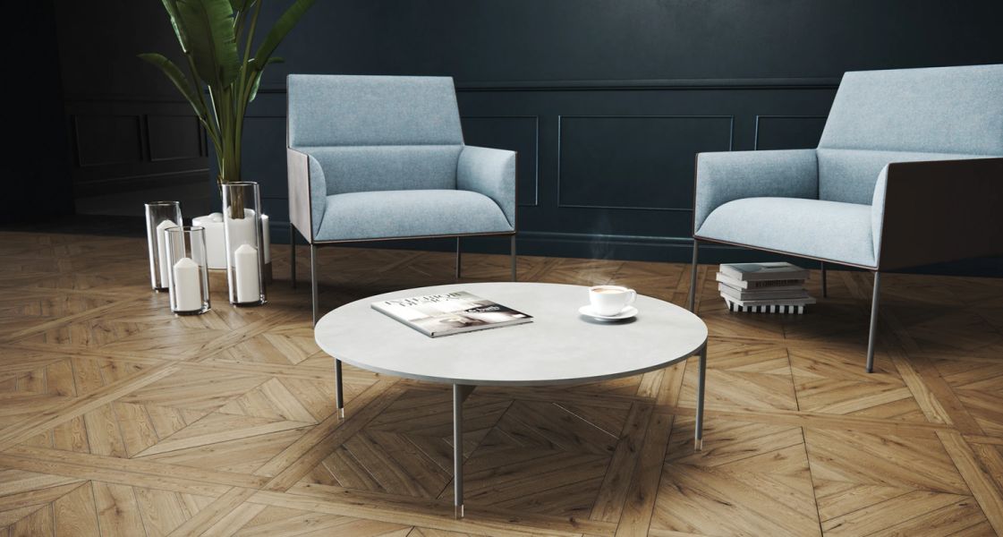 Nízky okrúhly stolík Chic Tables s časopisom a šálkou kávy medzi dvoma svetlomodrými kreslami