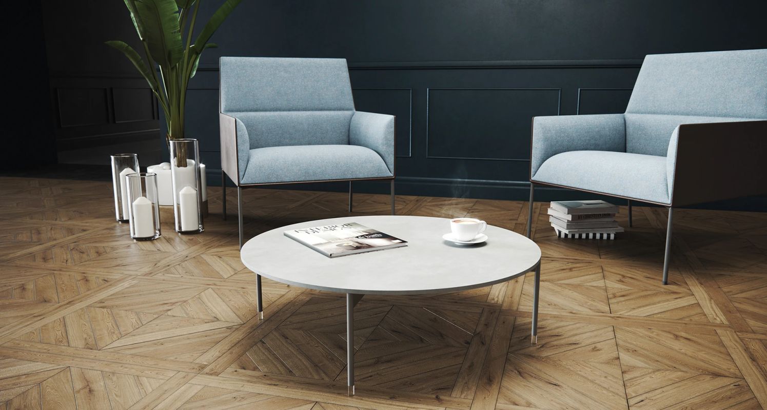 Nízky okrúhly stolík Chic Tables s časopisom a šálkou kávy medzi dvoma svetlomodrými kreslami