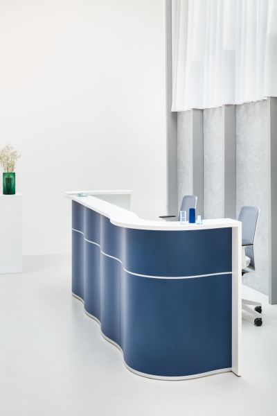 Modulárny recepčný pult Wave v modro-bielej farbe v minimalistickom svetlom interiéri