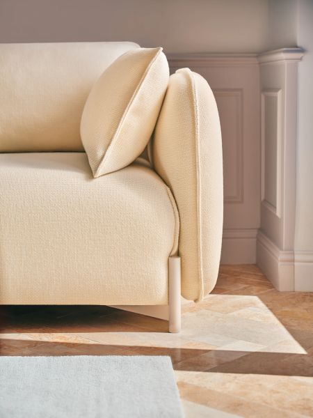 Detail béžového lounge kresla Linka s mäkkým čalúnením a vankúšmi v svetlej obývačke