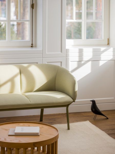 Elegantná pohovka Grace v svetlom lounge interiéri pri okne, s dreveným stolíkom a dekoratívnym vtáčikom