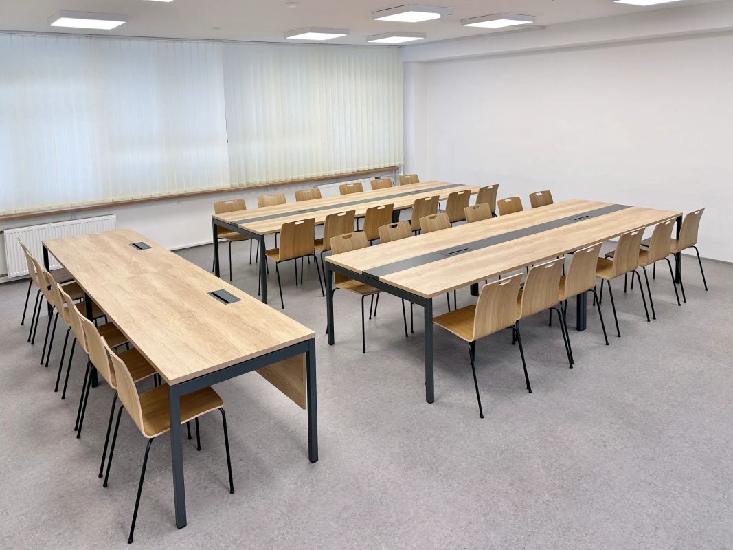 Školská zasadačka v Poprade s drevenými stolmi Ogi Y, clonami nôh, mediaboxmi a stoličkami Com H
