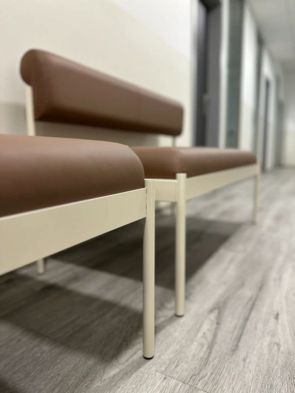 Hnedé čalúnené lavice v čakárni očnej kliniky v Brne s sivou vinylovou podlahou a bielymi stenami