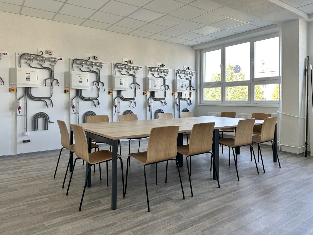 Školiaca miestnosť s Ogi Y stolmi, stoličkami a nástennými elektroinštalačnými panelmi