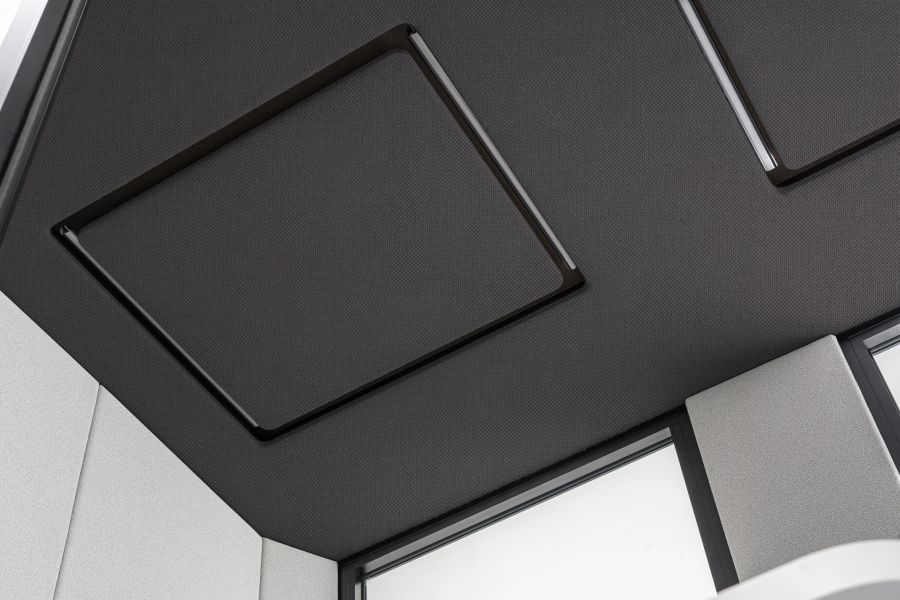 Detail stropu akustickej kabíny Coda so zabudovaným LED osvetlením a tmavým čalúnením