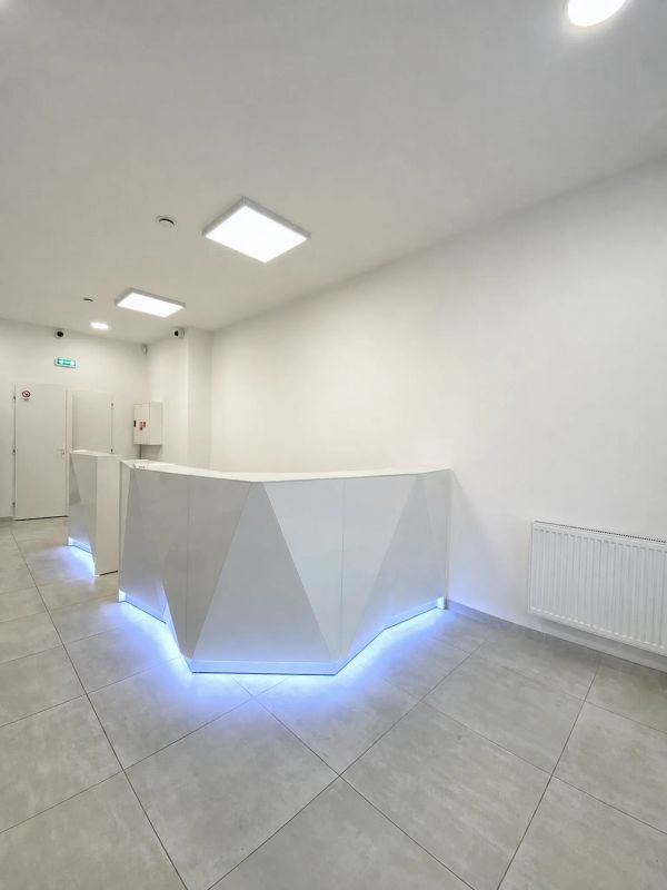 Biela recepcia kliniky v Nitre s modulárnym pultom Alpa a modrým LED podsvietením sokla