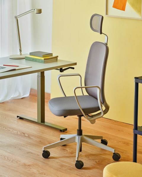 Ergonomická otočná kancelárska stolička Astro so záhlavníkom pri pracovnom stole v modernom interiéri