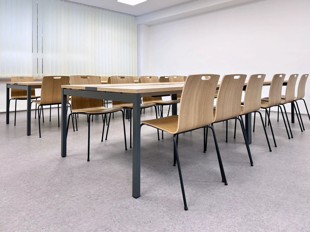 Školská zasadačková miestnosť v Poprade s radmi drevených stoličiek a stolov v svetlej triede