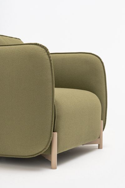 Detail zeleného lounge kresla Linka s mäkkým čalúnením a béžovými kovovými nohami