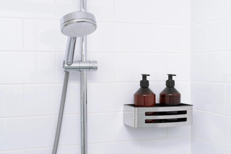 A clean, atmospheric shower scene with premium body wash bottles arranged on a shelf