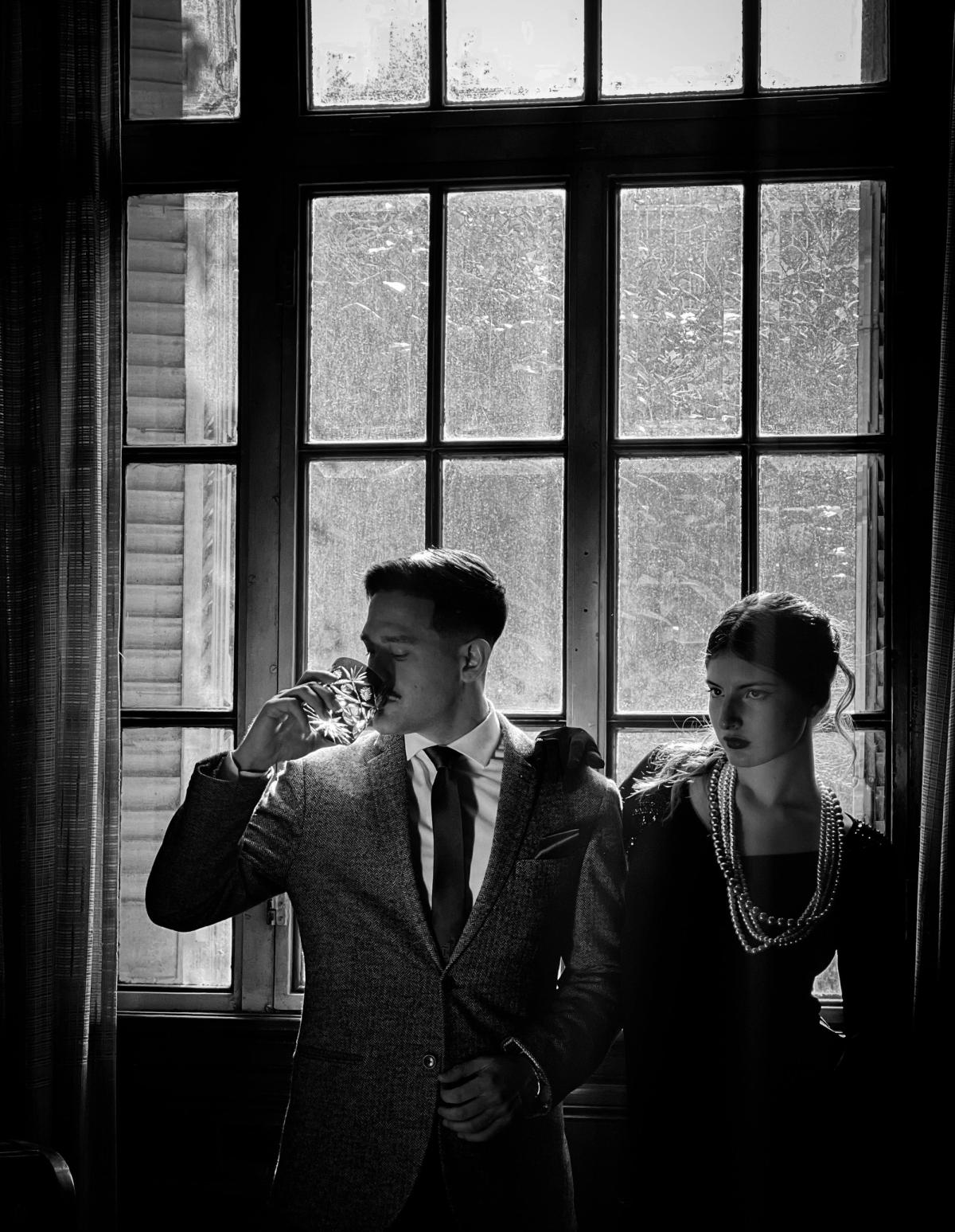 Well-dressed man applying old money cologne in a sophisticated grooming setting