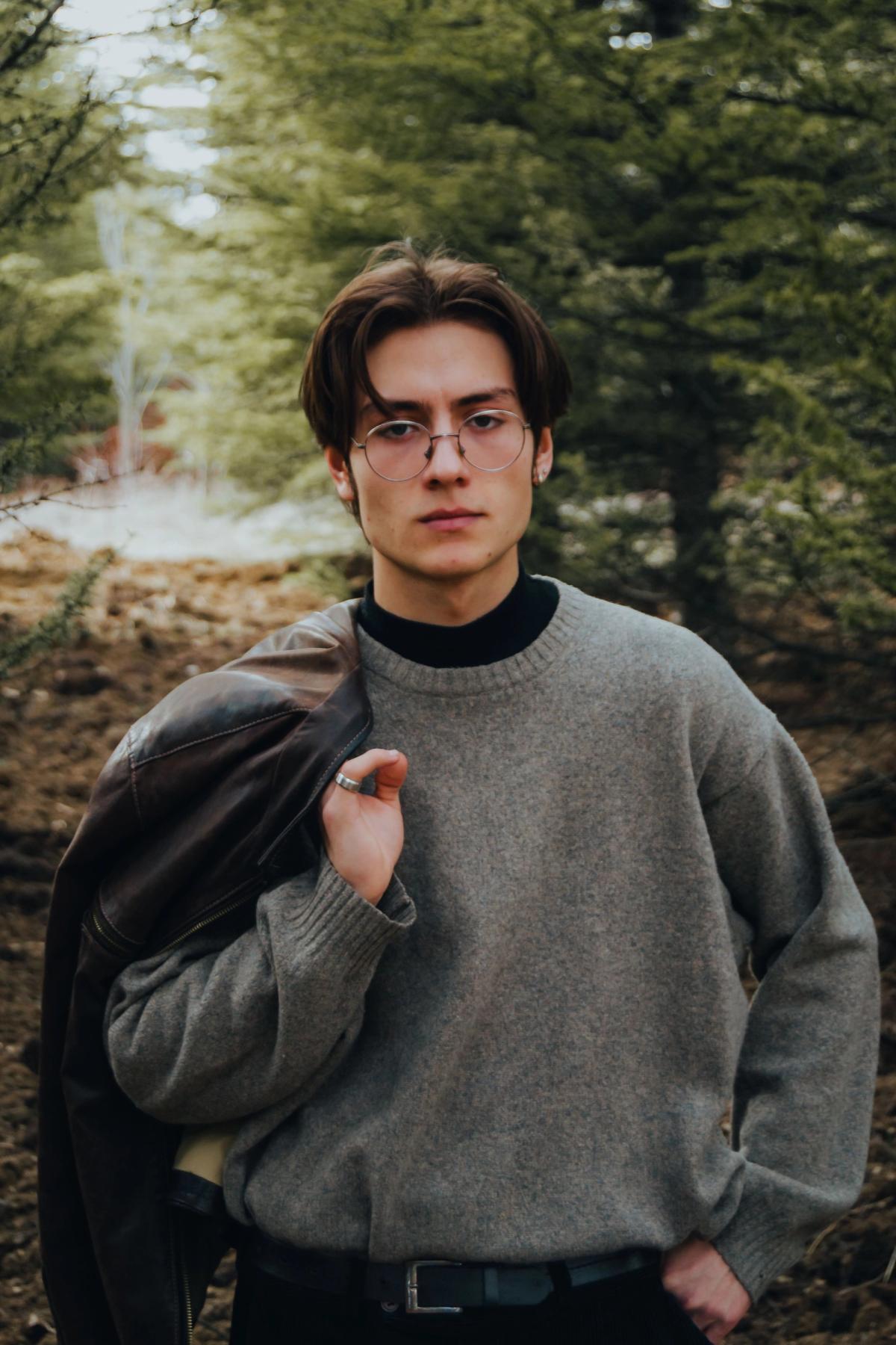 Man applying cologne while getting dressed representing 2026 Pinterest men's style aesthetics and scent profiles