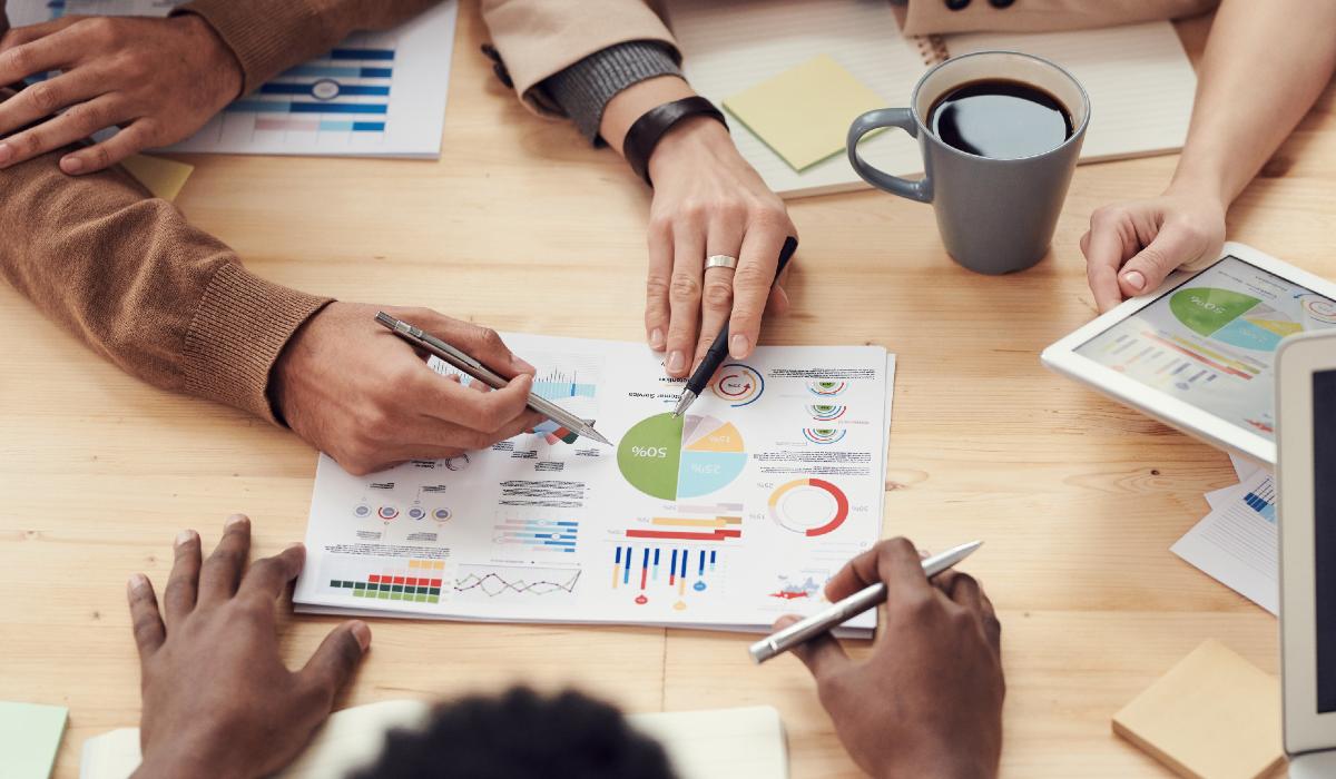 Funcionários discutem em cima de gráficos