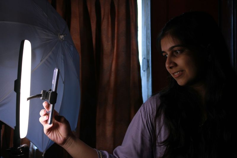 Creator filming a Reel with a phone in front of a ring light