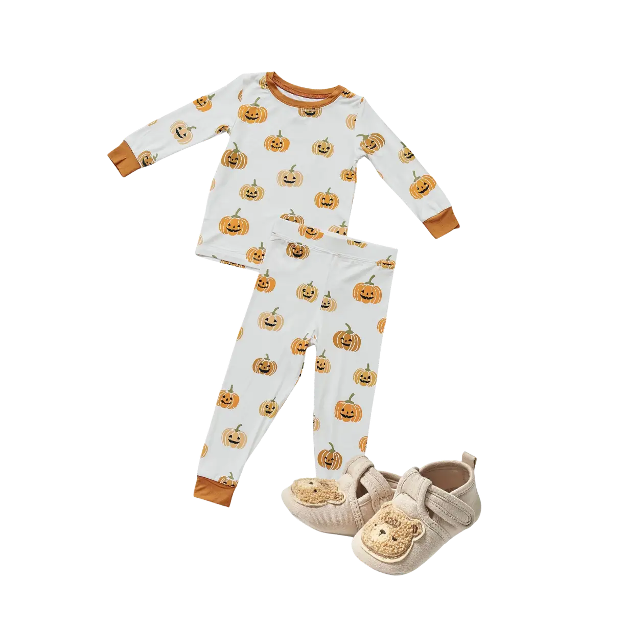 A white long-sleeved shirt and matching pants with an orange jack-o'-lantern pattern, paired with beige teddy bear baby shoes.