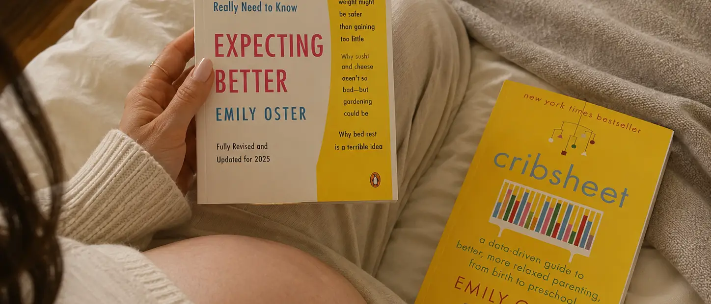 A pregnant person reads "Expecting Better" by Emily Oster, with "Cribsheet" by the same author lying nearby.