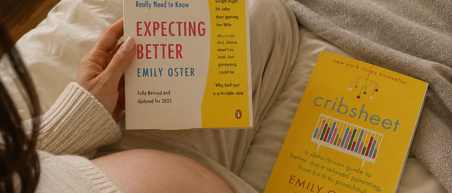 A pregnant person reads "Expecting Better" by Emily Oster, with "Cribsheet" by the same author lying nearby.