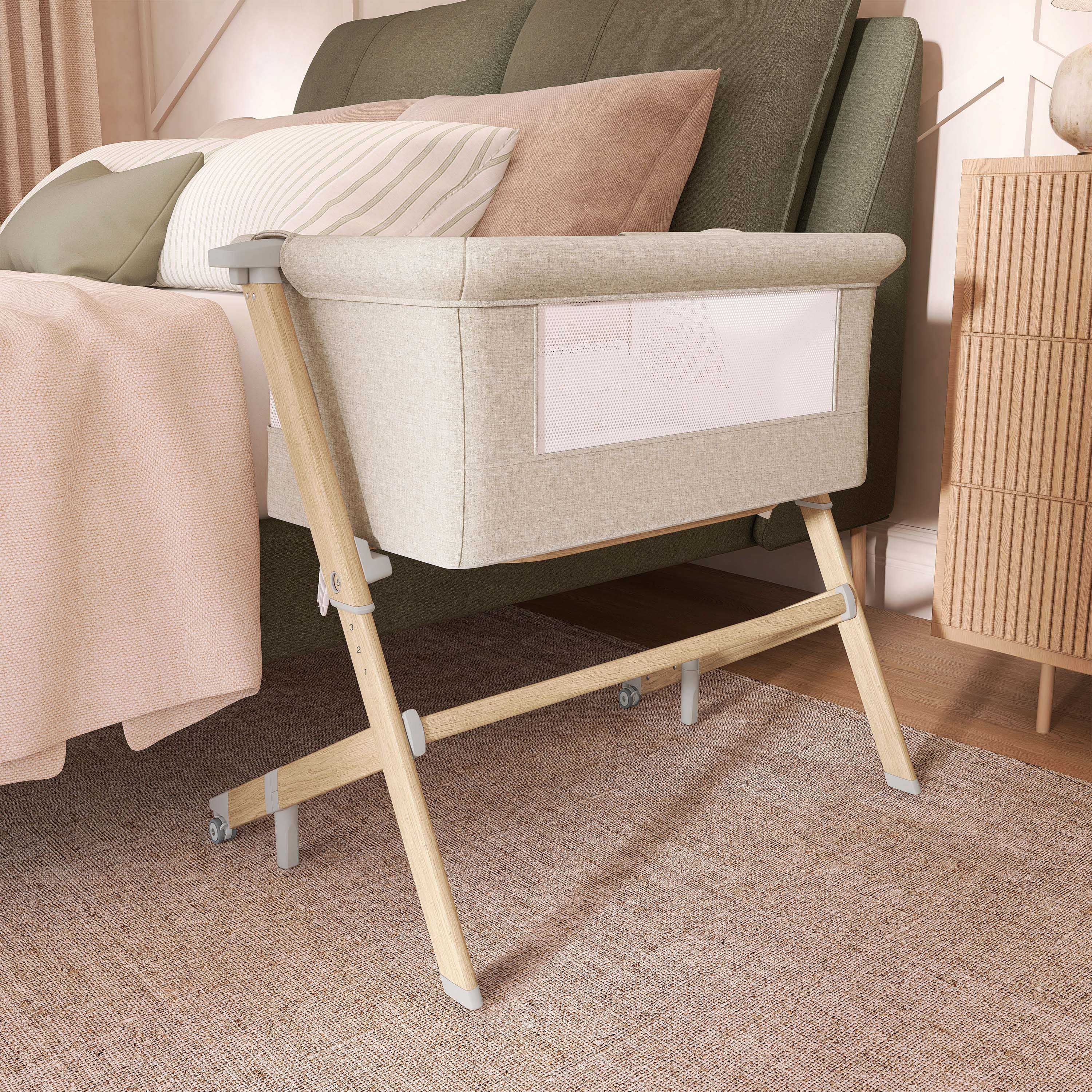 Evolur Stellar Bassinet and Bed side sleeper positioned next to a bed in a modern nursery bedroom