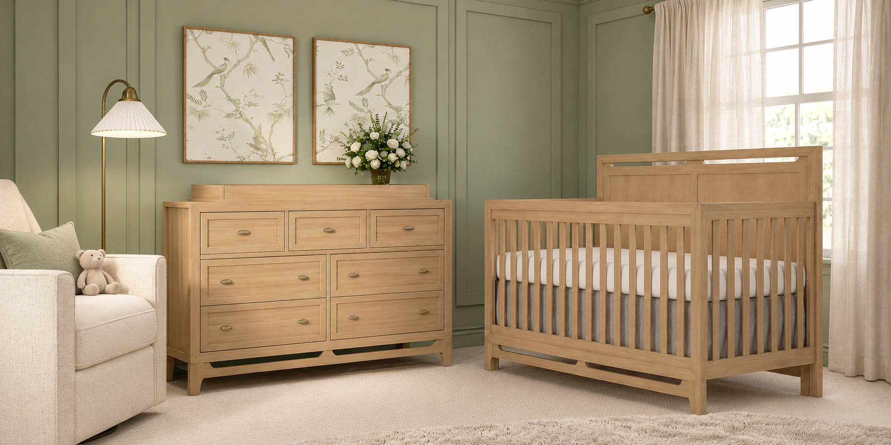 A serene sage green nursery with a natural wood crib, matching dresser with a changing top, and a cream glider.