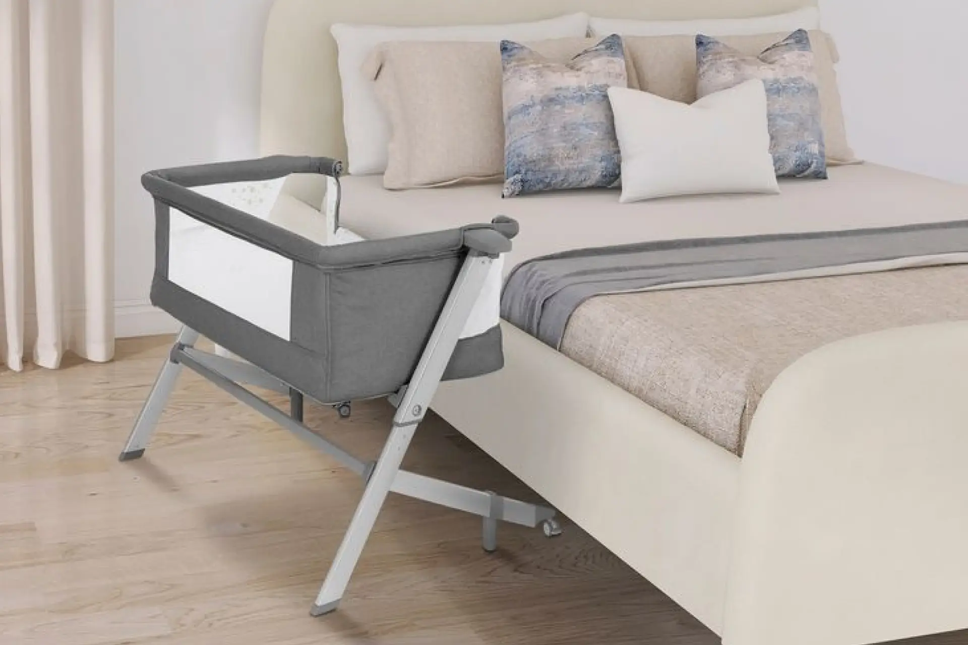 A sleek and modern Dream On Me Skylar Bassinet and Bedside Sleeper next to a bed