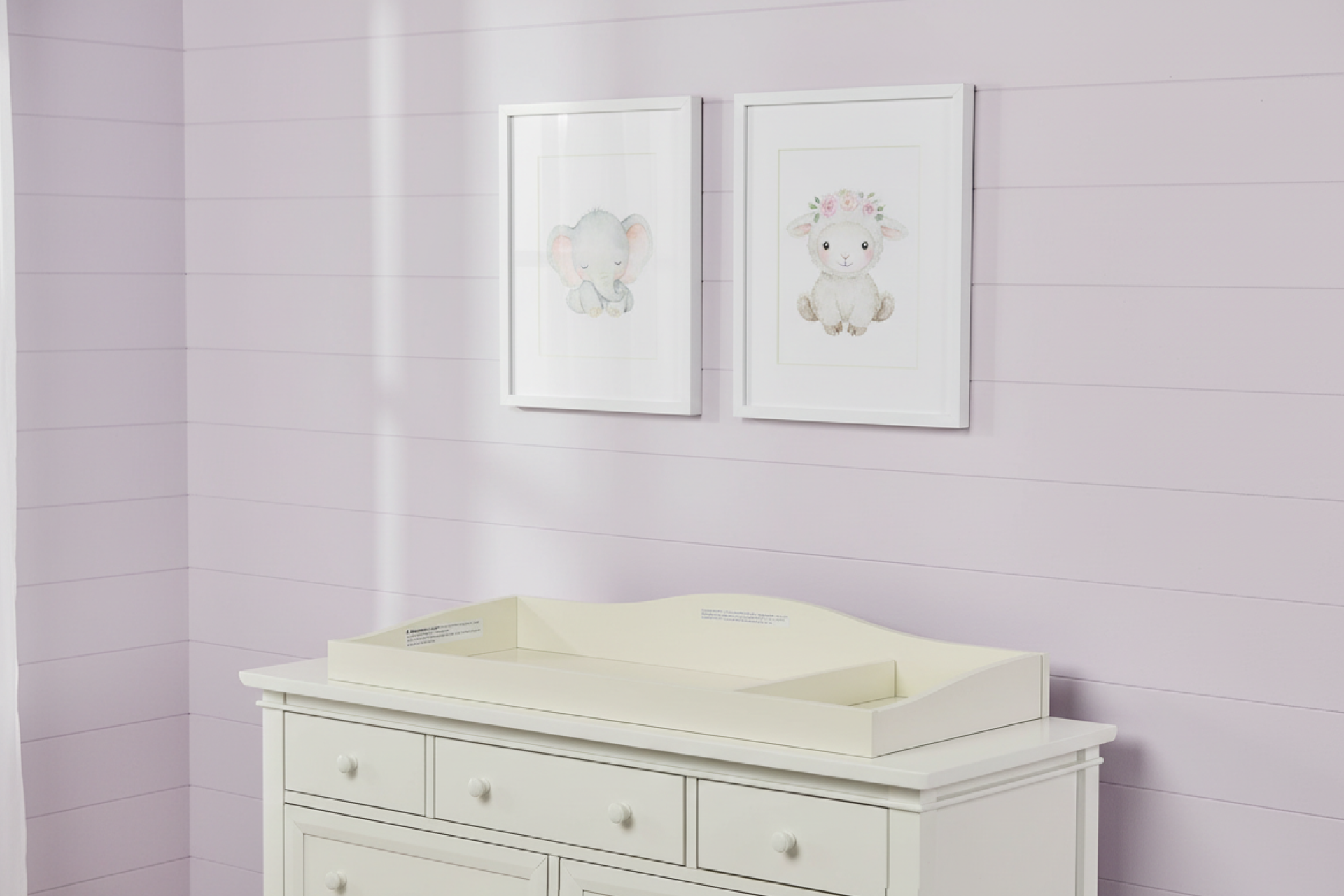 Evolur universal changing tray in frost white displayed on a nursery dresser against lavender walls