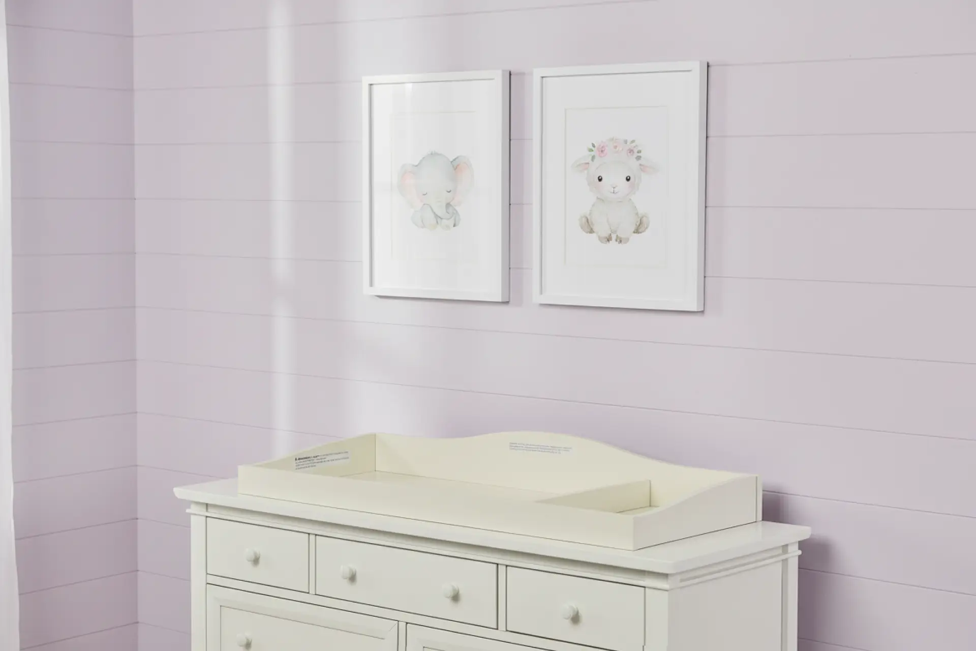 Evolur universal changing tray in frost white displayed on a nursery dresser against lavender walls
