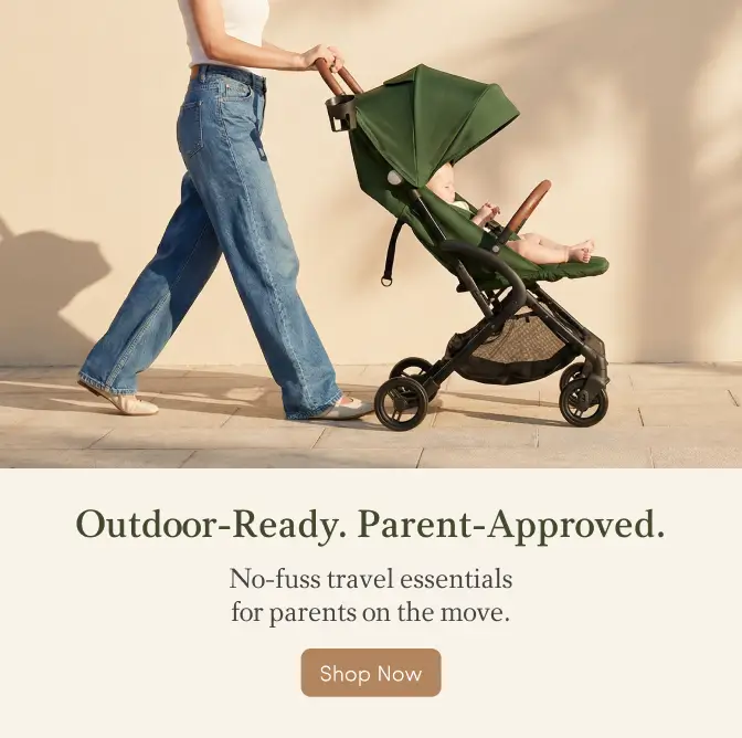 Adult pushing a baby in a dark green stroller outdoors, advertising travel essentials.