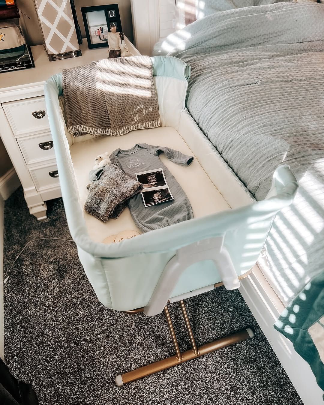 Cozy nursery setup featuring Evolur Orabelle Bassinet and Bedside Sleeper with baby essentials, styled in natural light beside a bed.