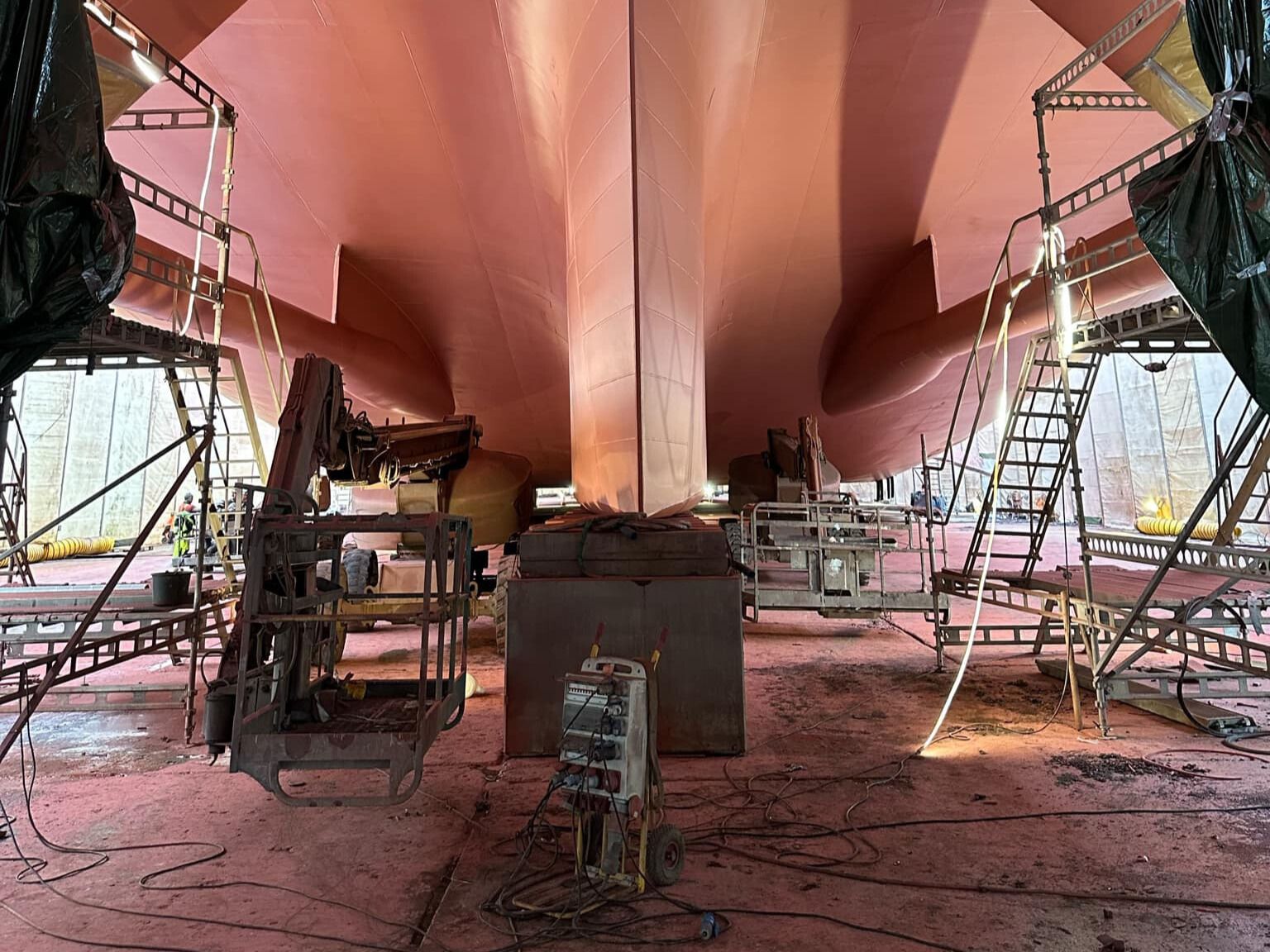 a large boat is being built in a warehouse .