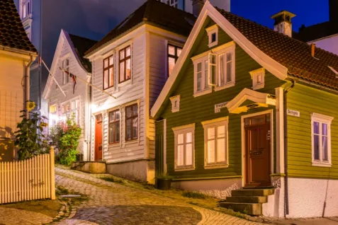 a row of houses on a cobblestone street at night .
