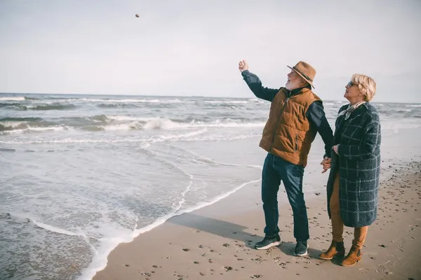 Eldre par på sandstrand.