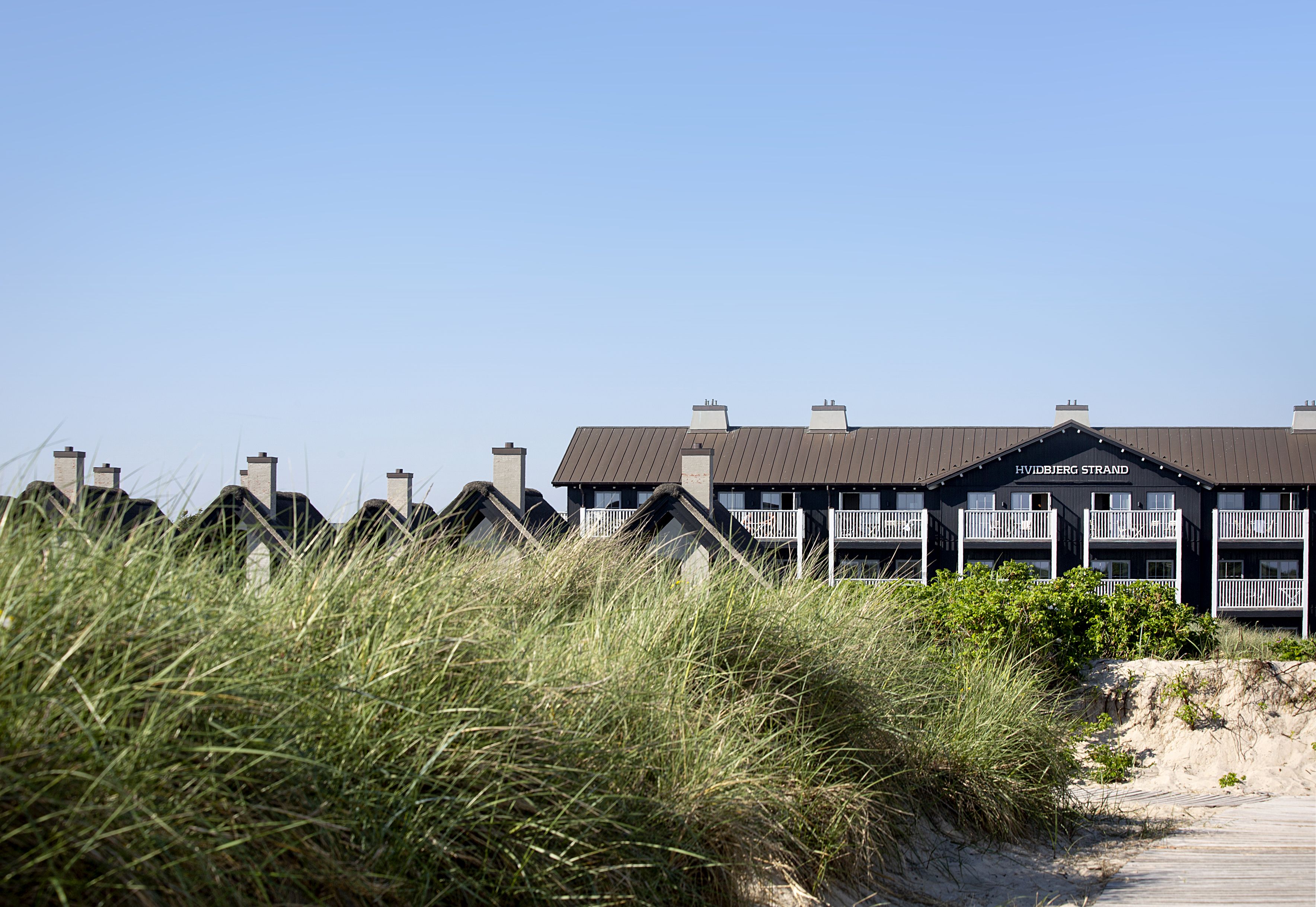 en husrekke på toppen av en sanddyne .