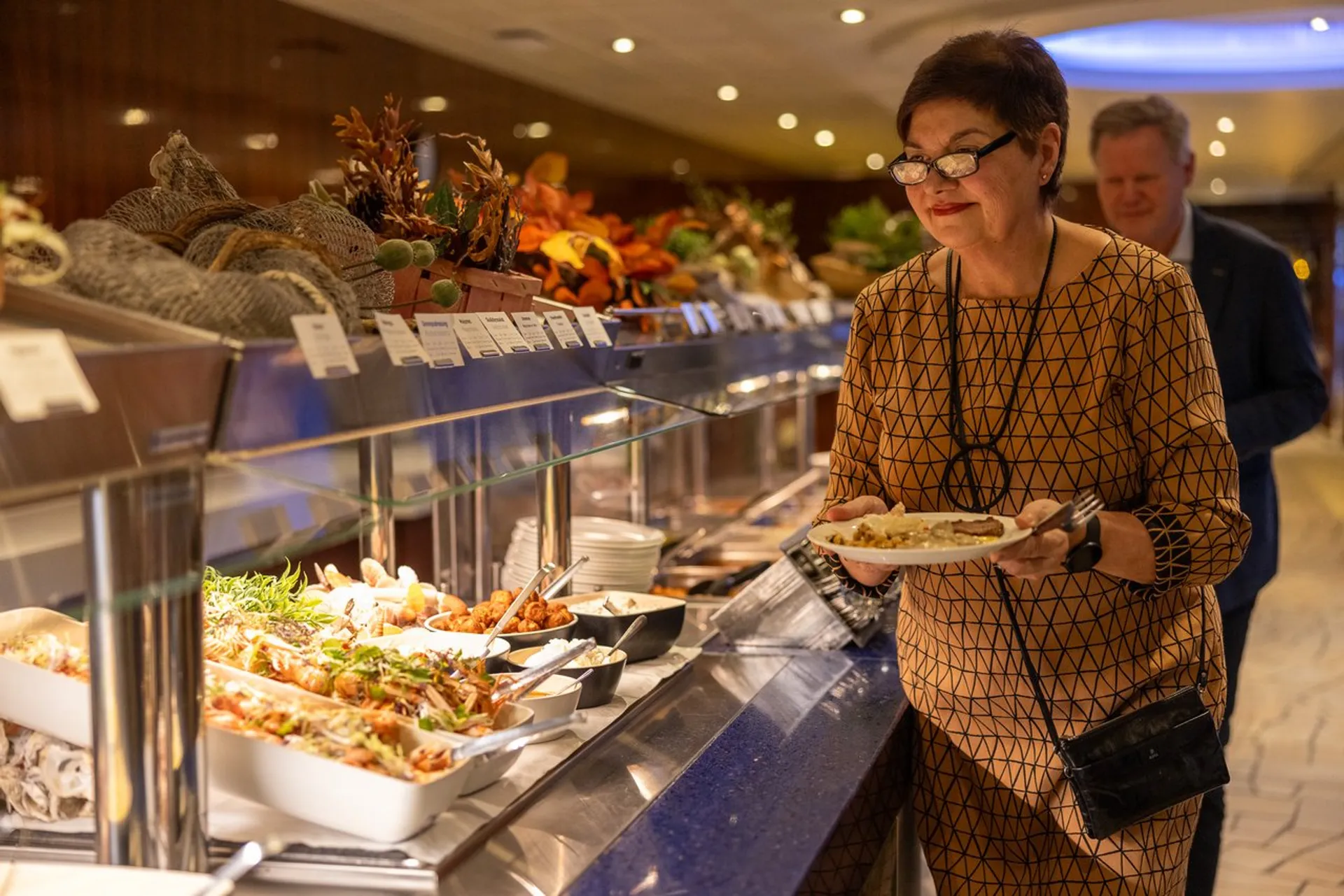 Dame og mann forsyner seg med mat fra buffet.