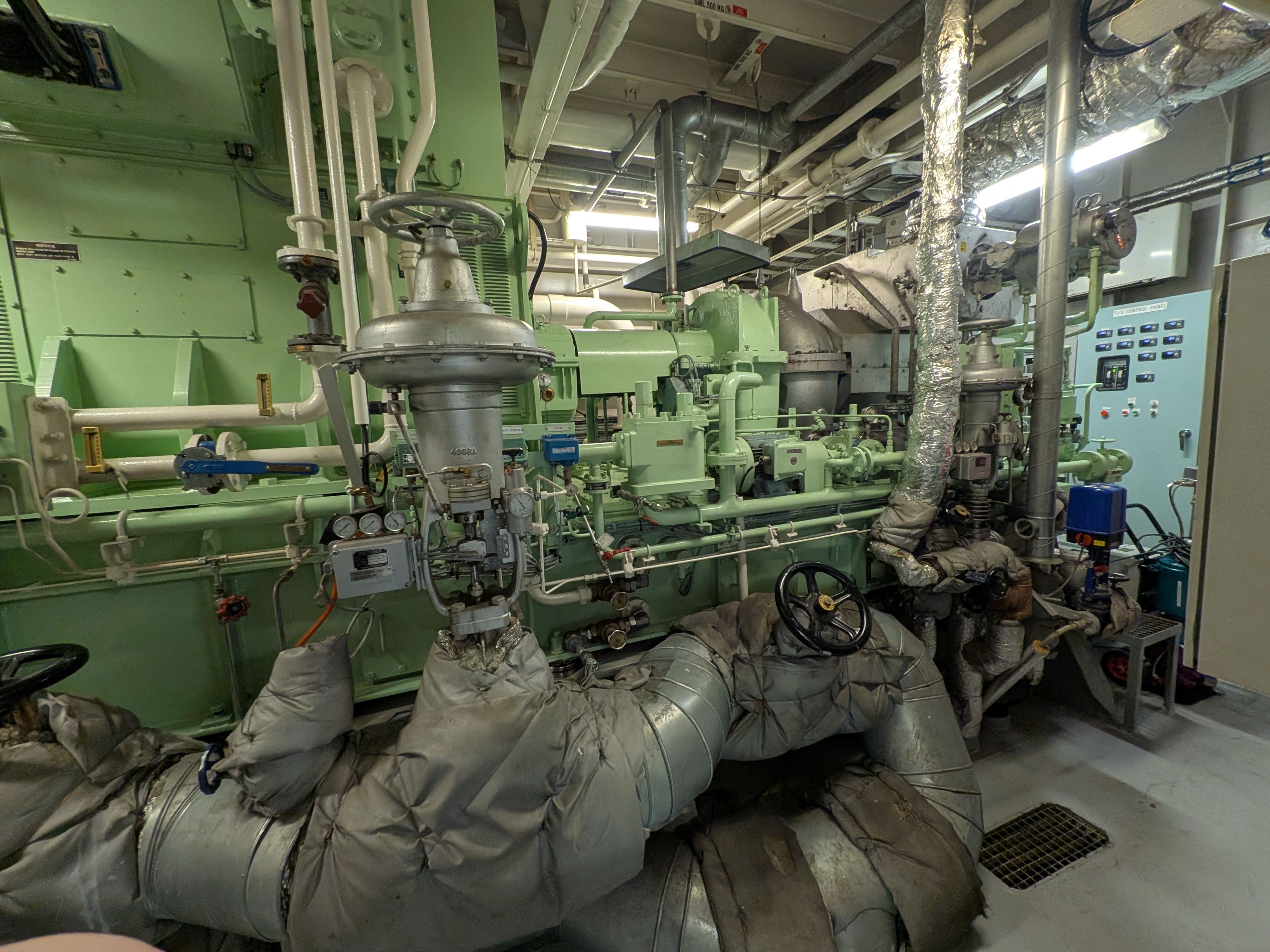 a room filled with lots of pipes and valves on a ship .