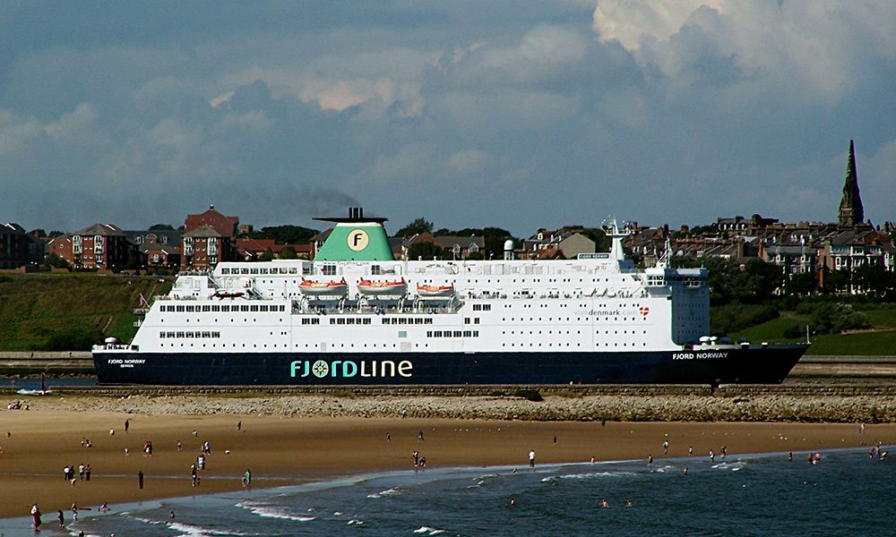 a large cruise ship is docked on the shore of a beach .